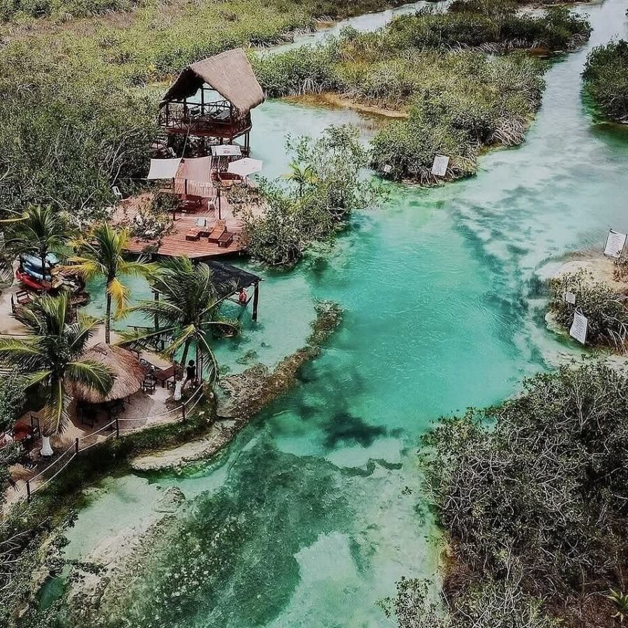 Aerial view of Los Rápidos de Bacalar resort, surrounded by a winding river and lush greenery.