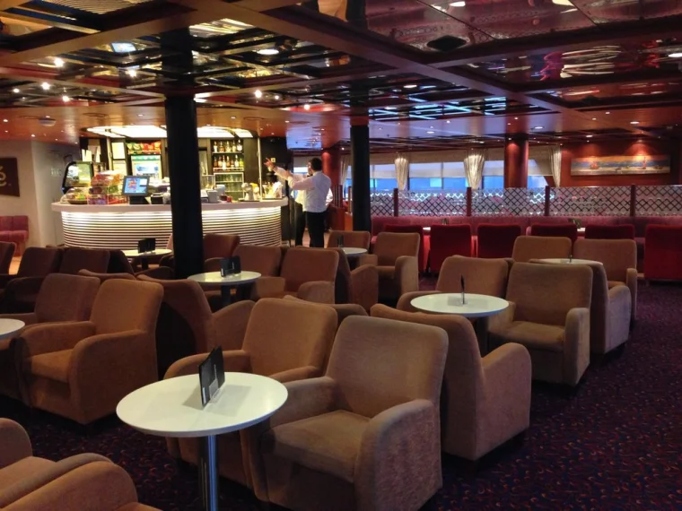 Luxury cruise ship lounge with elegant decor, cozy seating, and a stylish bar.