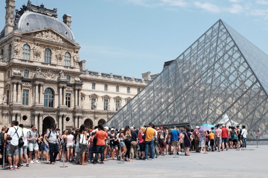 Visitors queue outside the Louvre during a 2015 strike, highlighting its iconic allure and challenges.