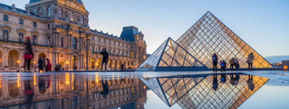 iew of famous Louvre Museum with Louvre Pyramid at evening