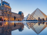 iew of famous Louvre Museum with Louvre Pyramid at evening