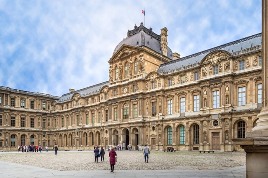Historic Louvre Museum, Paris: Grand classical architecture, sandy stone, tourists admire ornate façade.