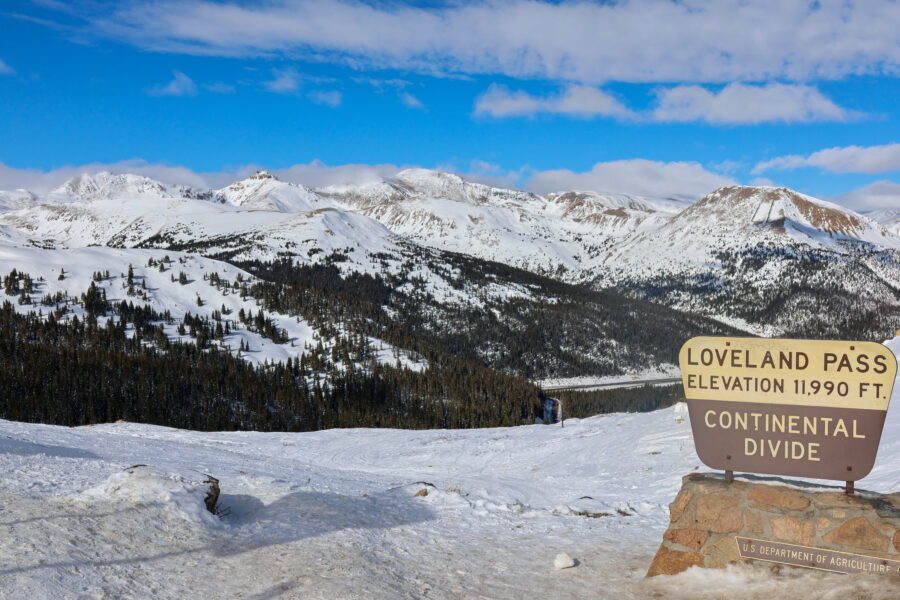 Loveland Pass sign with snowy mountains in the background, showcasing a winter landscape in Colorado