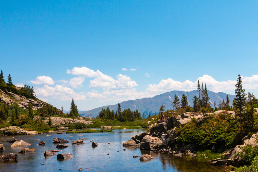 Scenic view of Lower Mohawk Lake in Breckenridge, Colorado, surrounded by lush greenery and majestic mountains