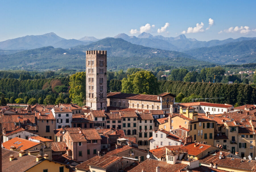 Aerial view of Lucca, Italy, showcasing its historic walls, terracotta rooftops, and surrounding green hills