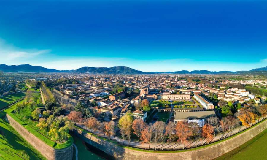 Aerial view of Lucca, a medieval town in Tuscany, showcasing its historic architecture and surrounding greenery