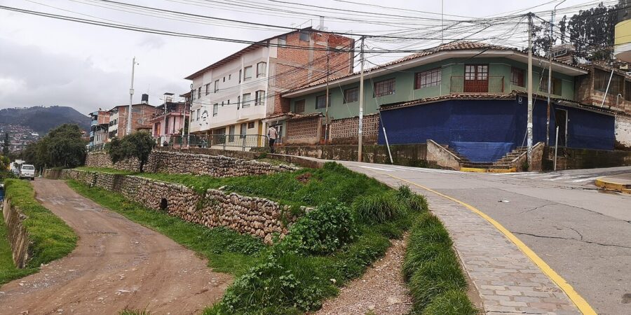 Residential street in Lucrepata, Cusco, Peru, with houses flanking the road that stretches down the center.