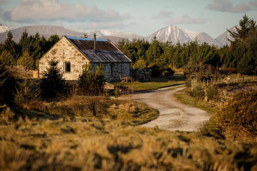 Weathered stone house is situated in a vast field, showcasing rural charm in Lusa, United Kingdom.