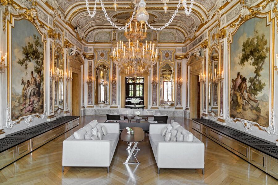Luxurious opulent interior with classic elegance, modern design, chandelier, murals, and plush seating.