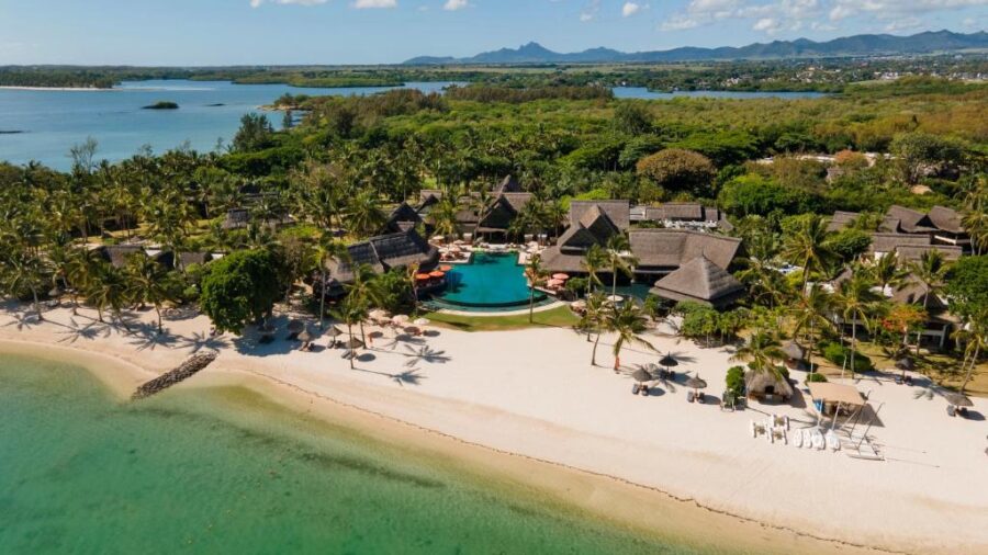 Aerial view of luxury Mauritius beach resort with infinity pool, palm trees, white sand and lagoon.