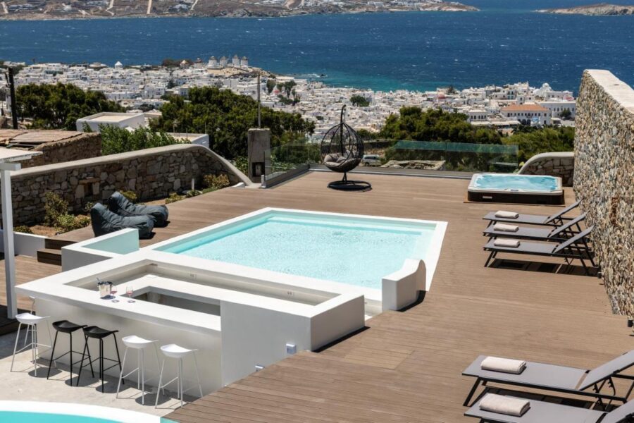 Luxurious Mykonos terrace with pool, sea views, lounging and bar area.