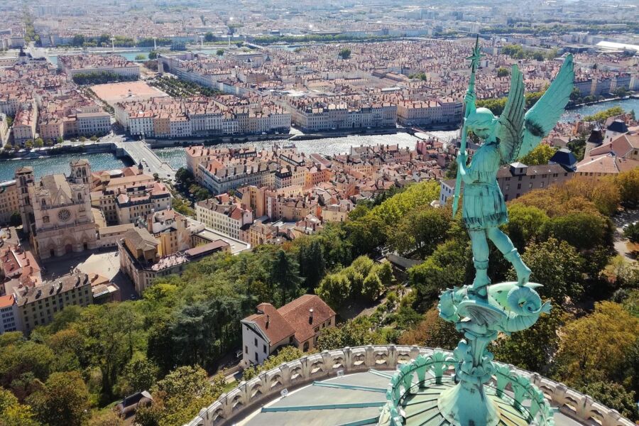 Breathtaking aerial view of Lyon with historic buildings, river, and St. Michael statue.