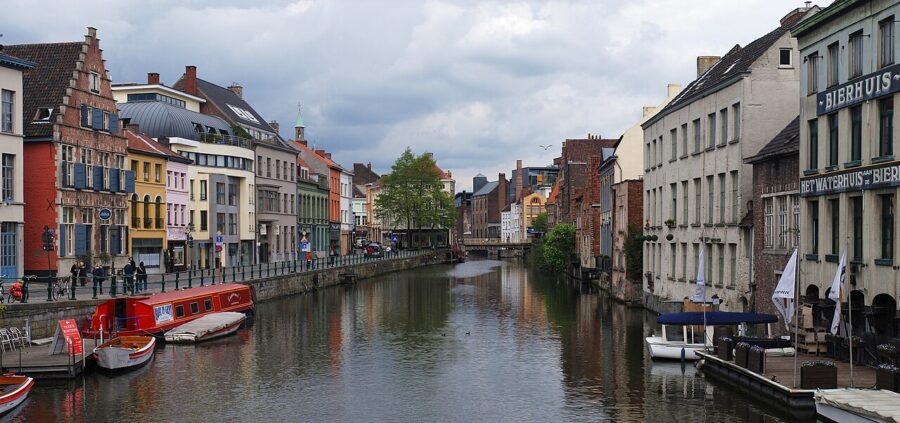The Lys River in Gent, Belgium, showcasing boats on the water with charming buildings along the canal's banks.
