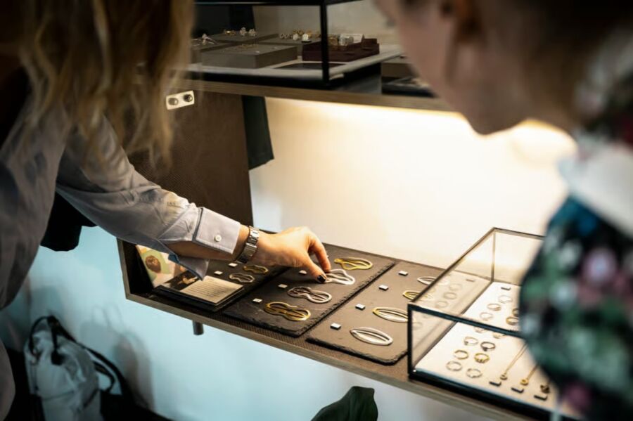 Two women examining jewelry in a store during a guided tour of Made in Zurich products.