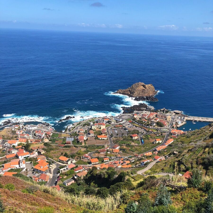 Panoramic view of a town by the sea from a hill in Madeira Islands, Portugal, highlighting the region's stunning landscape.
