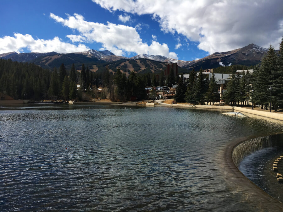 Tranquil Maggie Pond in Breckenridge, Colorado, reflecting the surrounding mountains and trees on a sunny day