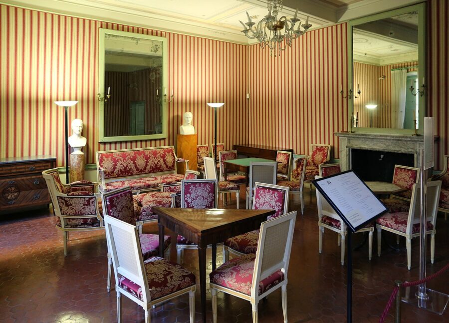 Interior of Maison Bonaparte in Corsica, showcasing a room filled with chairs and tables for gatherings.