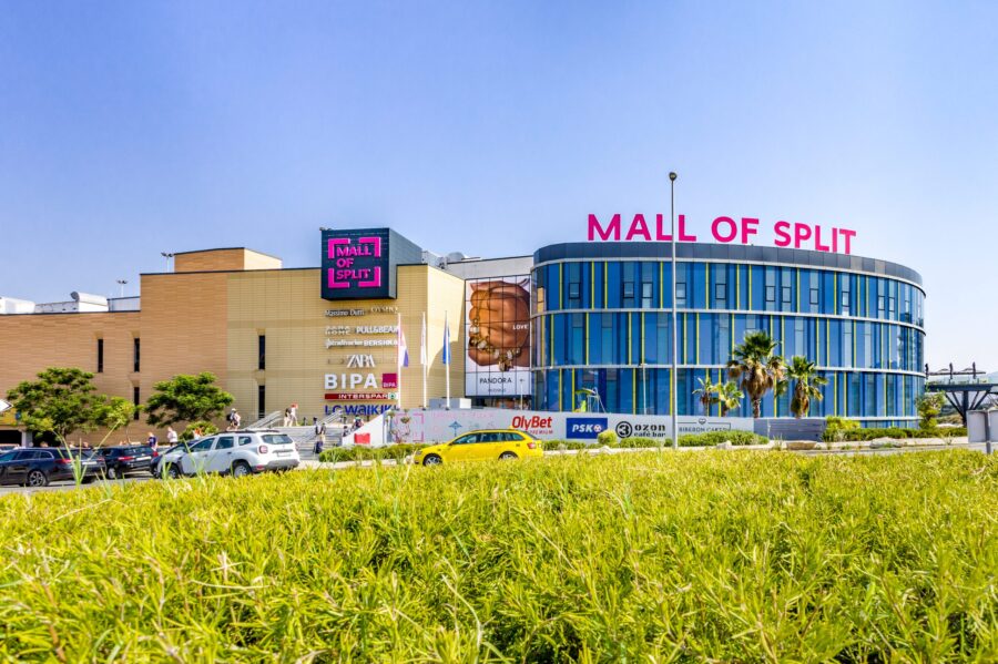 Exterior view of Mall of Split in Croatia, featuring modern architecture and lush landscaping.