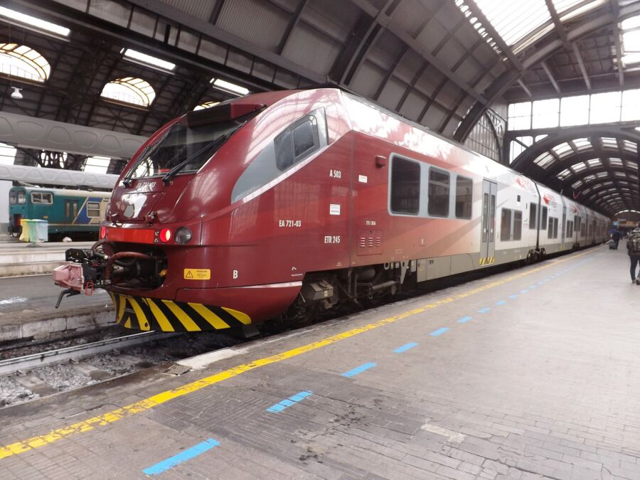 Red Malpensa Express train at a train station, ready for passengers to board.