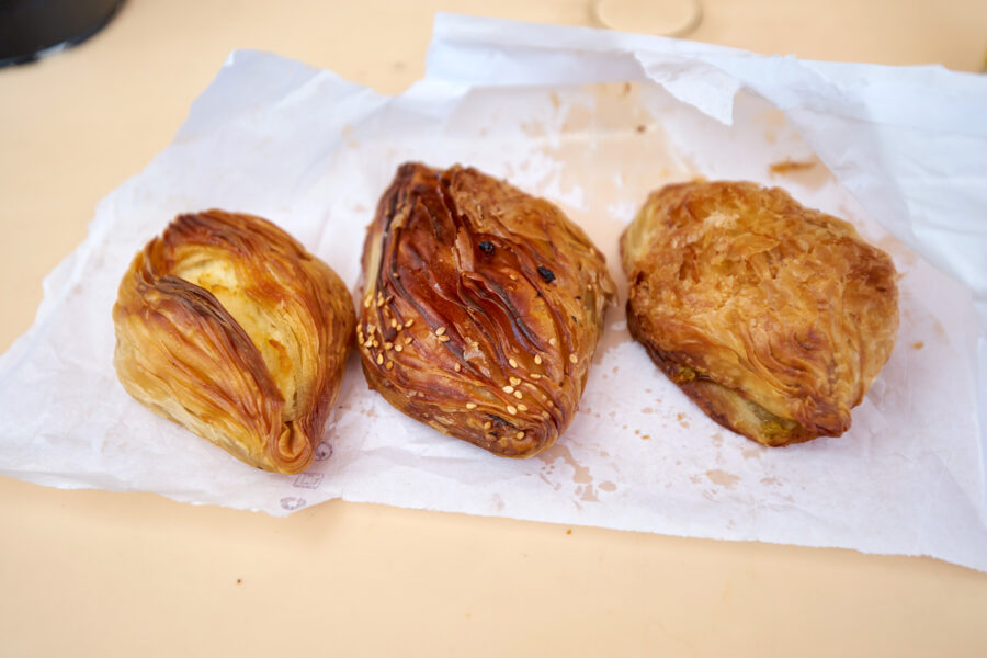 Freshly baked Maltese pastizzi displayed on the counter of a cozy pastizzeria, inviting customers to enjoy a delicious treat.