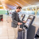 Man using the check-in machine at the airport