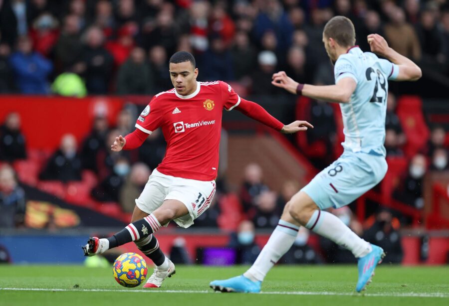Manchester United player action shot during a match against a light blue team.