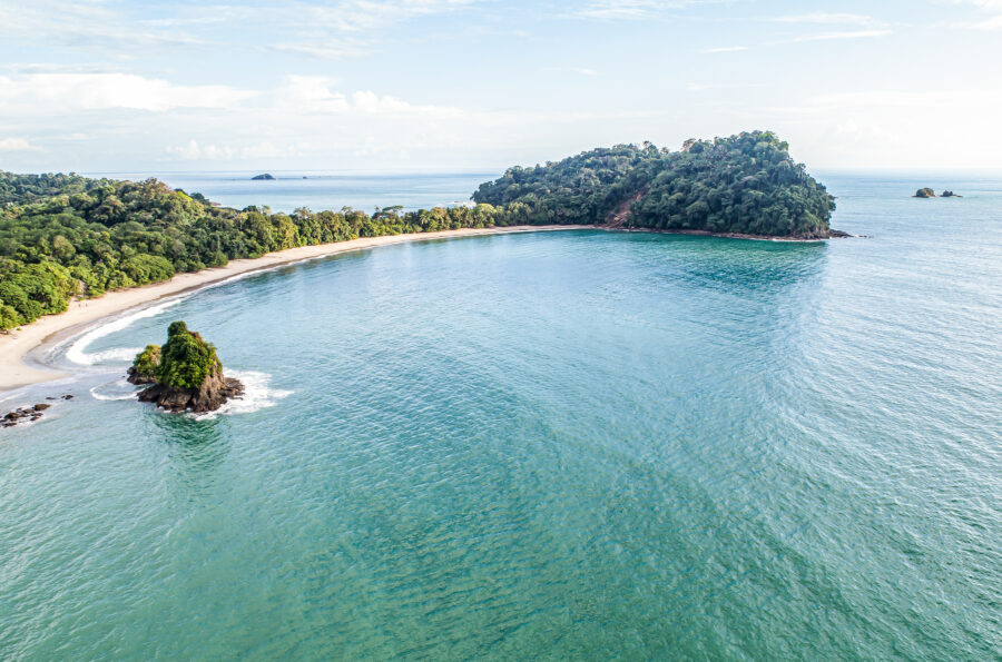 Aerial view of Espadilla Beach and coastline near Manuel Antonio National Park, showcasing lush greenery and turquoise waters