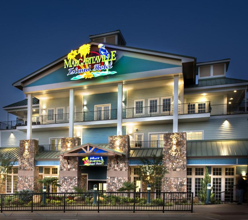 The exterior of Margaritaville Island Hotel illuminated at dusk, showcasing its welcoming entrance and surrounding ambiance.