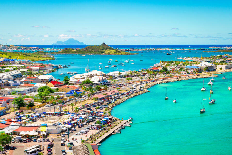 Aerial view of Marigot Bay in St. Martin, showcasing turquoise waters and lush green hills in the Caribbean
