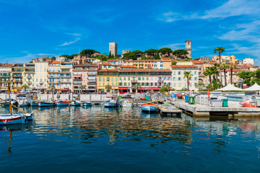 Scenic view of the marina and city center of Cannes, showcasing boats and vibrant buildings in Southern France