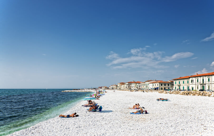 Scenic view of Marina di Pisa, showcasing the coastline, boats, and Tuscan architecture under a clear blue sky