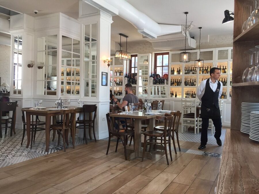 In Markata e Peshkut, Tirana, a man stands confidently in the middle of the restaurant, engaging with the atmosphere.