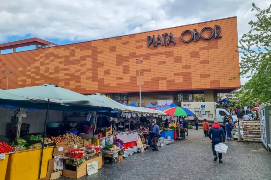 Bustling Piata Obor market with fresh produce, vibrant stalls, and diverse shoppers.