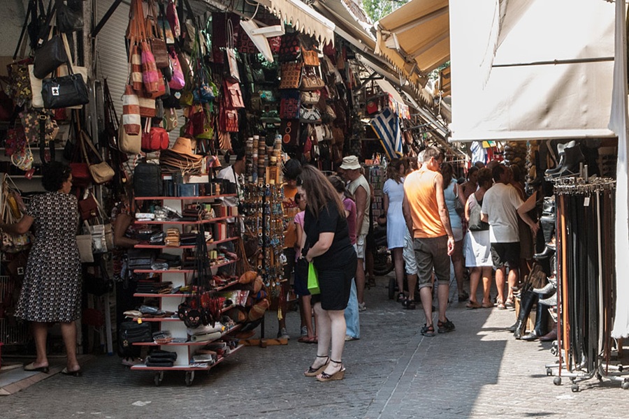 Vibrant market scene with colorful handmade crafts and diverse shoppers exploring artisanal goods.