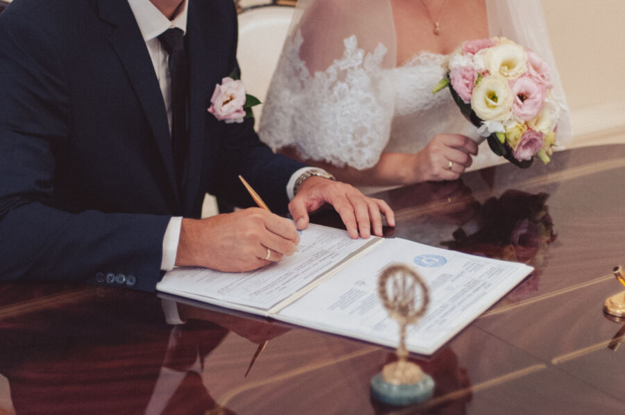 The bride and groom sign their marriage license and documents