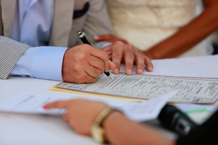 Bride and groom are signing their marriage documents at a signature ceremony
