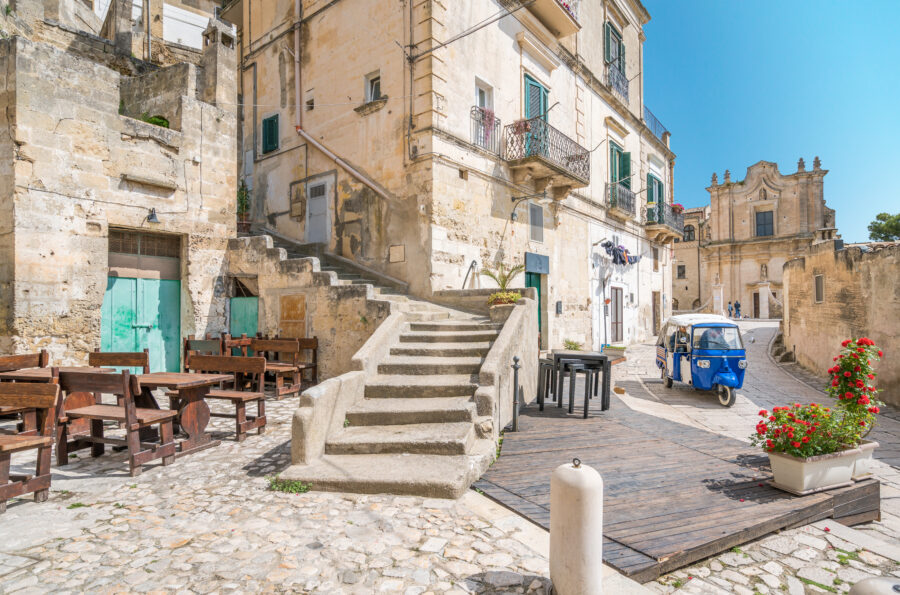 Scenic view of Matera, Basilicata, showcasing ancient stone buildings and dramatic cliffs under a clear blue sky.