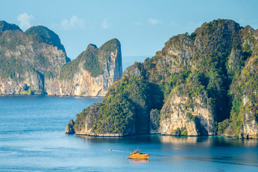 Panoramic view of Maya Bay beach in the Phi Phi Islands, showcasing its stunning turquoise waters and lush green cliffs
