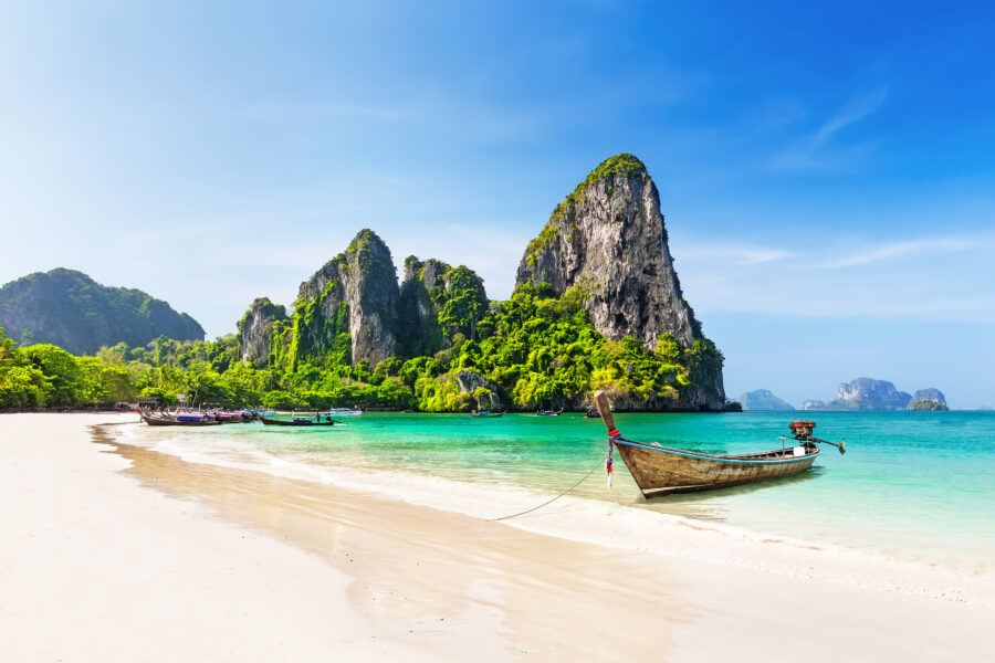 Traditional Thai longtail boat anchored near the sandy beach of Maya Bay, Phi Phi Islands, surrounded by clear blue waters