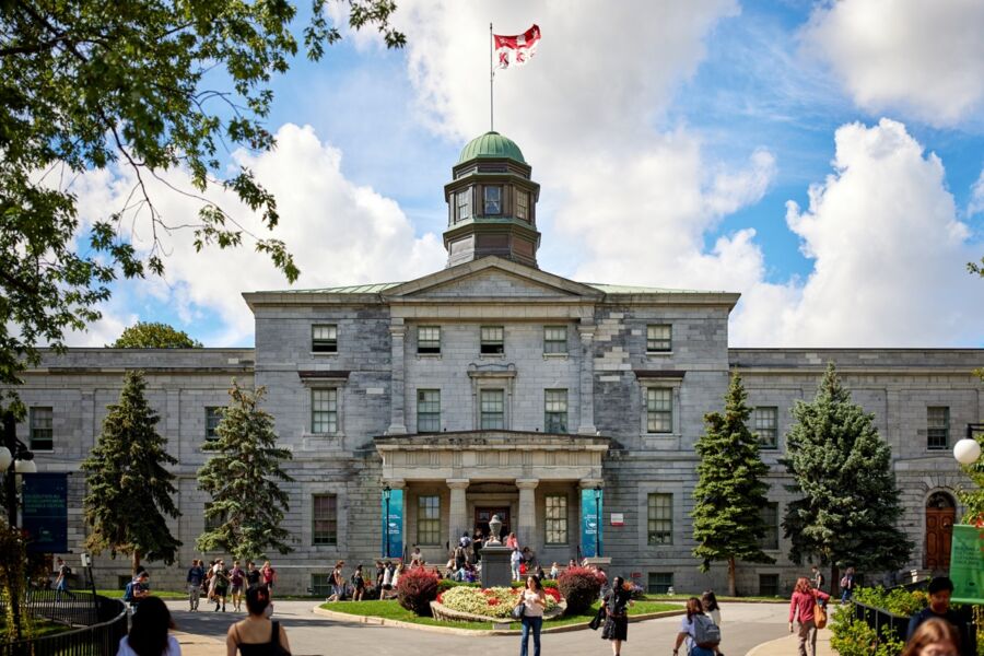 McGill Universitys Arts Building in Montreal, neoclassical architecture with dome and Canadian flag.