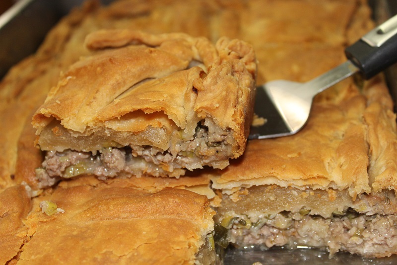 Homemade kreatopita: savory meat pie with golden crust and seasoned filling.
