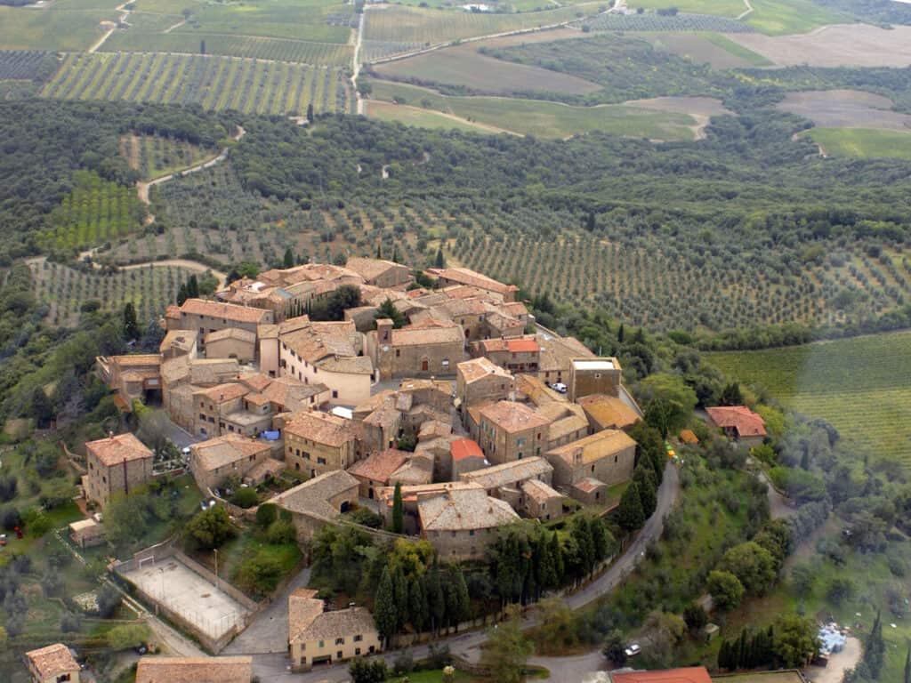 Aerial view of charming medieval Montalcino village with vineyards and olive groves.