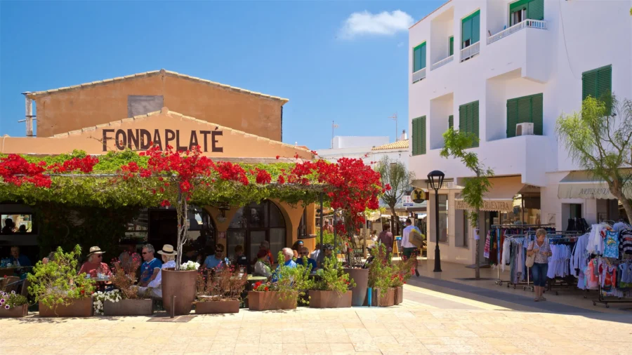 Mediterranean sunlit cafe plaza with bougainvillea, outdoor dining, and boutique shops.