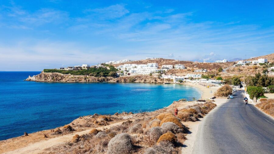 Picturesque Mediterranean coastal scene with turquoise waters, sandy beaches, and whitewashed hillside buildings.