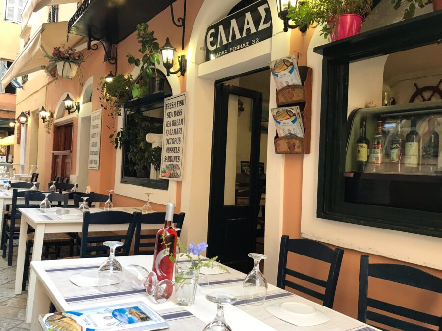 Charming Greek restaurant with outdoor seating, warm ambiance, and seafood menu in Mediterranean setting.