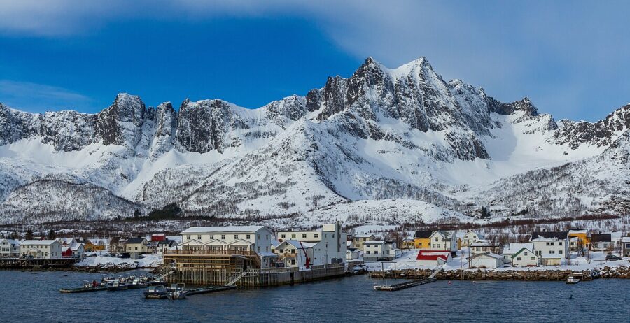 Mefjordvær, a quaint town in Norway, set against a backdrop of snowy mountains on Senja Island.
