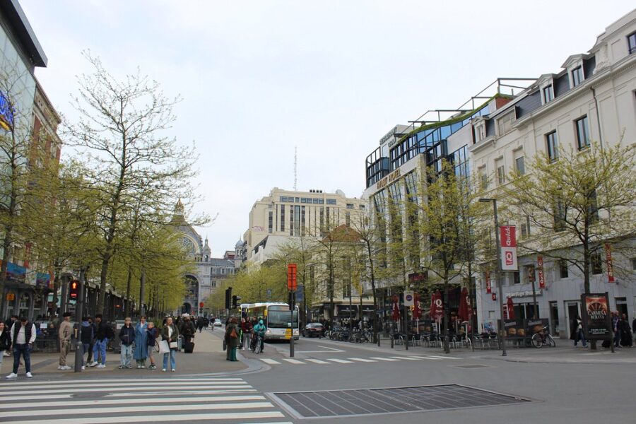 Bustling Meir District street in Antwerp, Belgium, filled with pedestrians walking and crossing the road.
