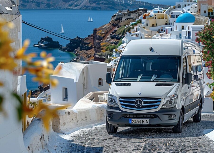 Mercedes van on Santorini cobblestone street with sea view and traditional architecture.