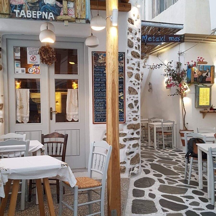 Exterior view of Metaxi Mas restaurant in Greece, featuring traditional architecture and outdoor seating