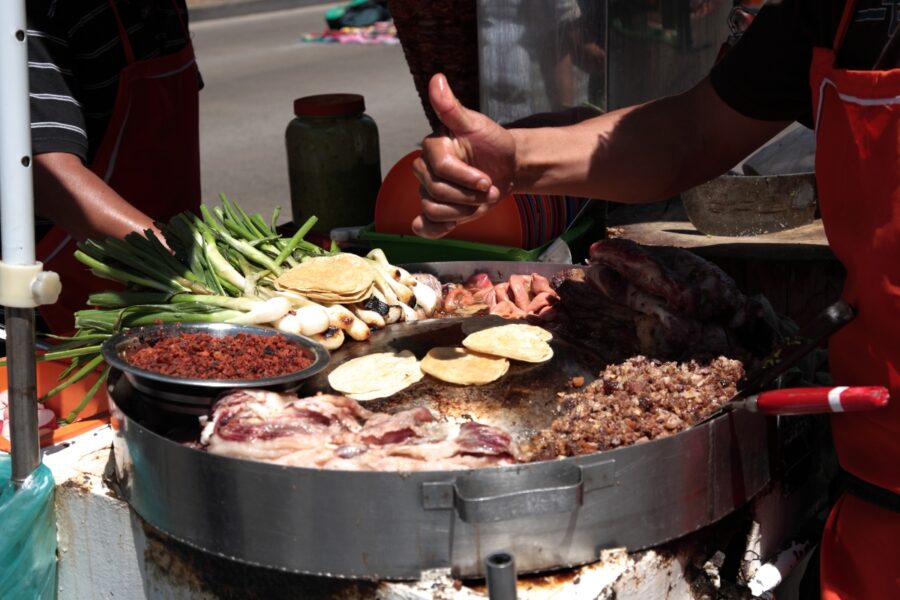 Delicious tacos adorned with toppings and a thumbs up, highlighting the street food culture in downtown Mexico City
